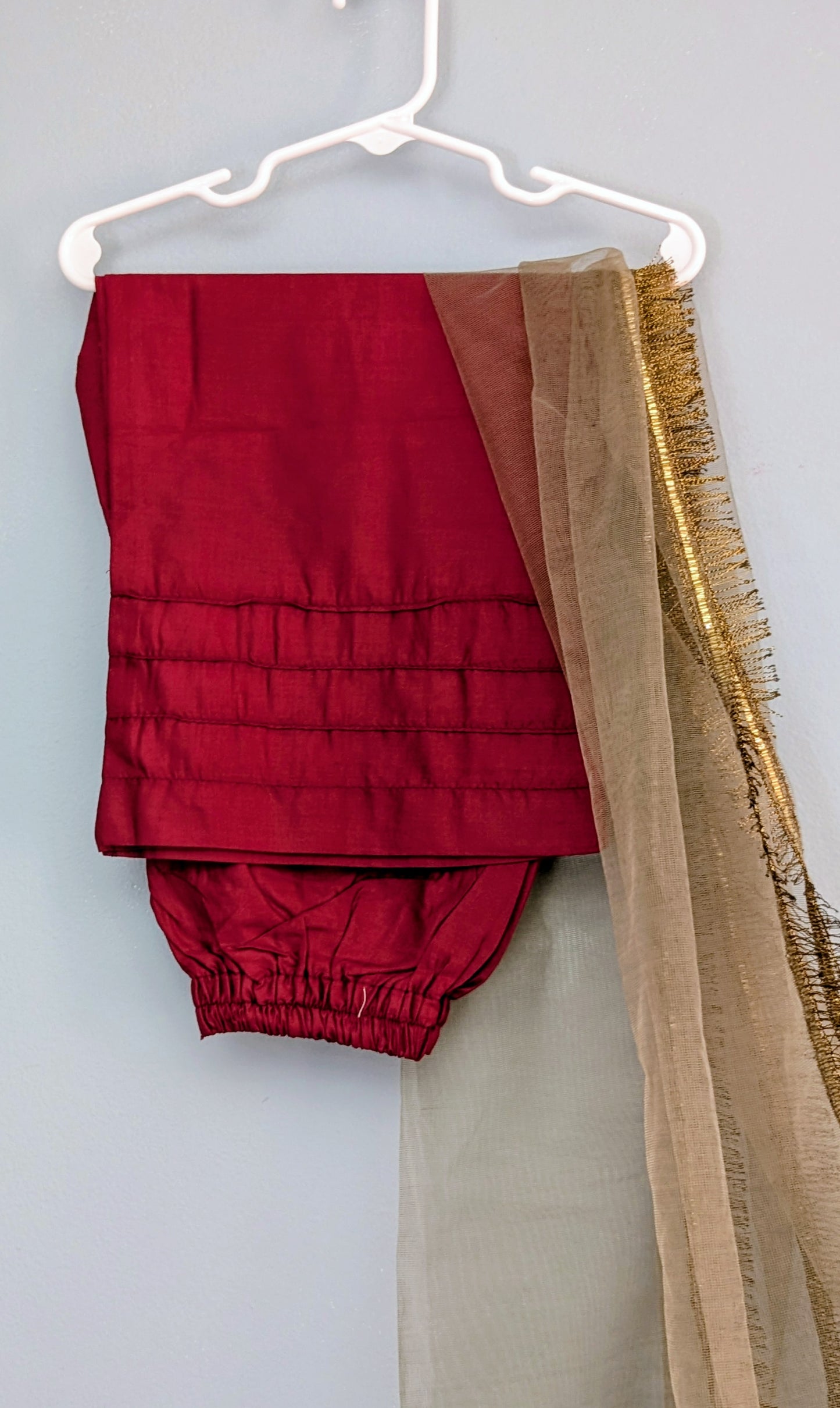 Girls maroon fully embroidered lawn kurta with matching trouser and gold dupatta.