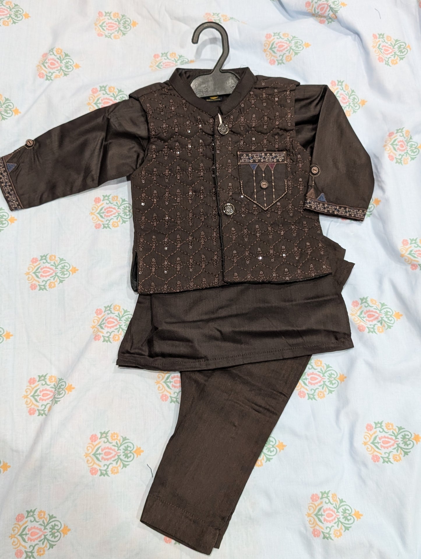 Infant dark brown kurta, matching trousers, and an embroidered, sequin-accented waistcoat.