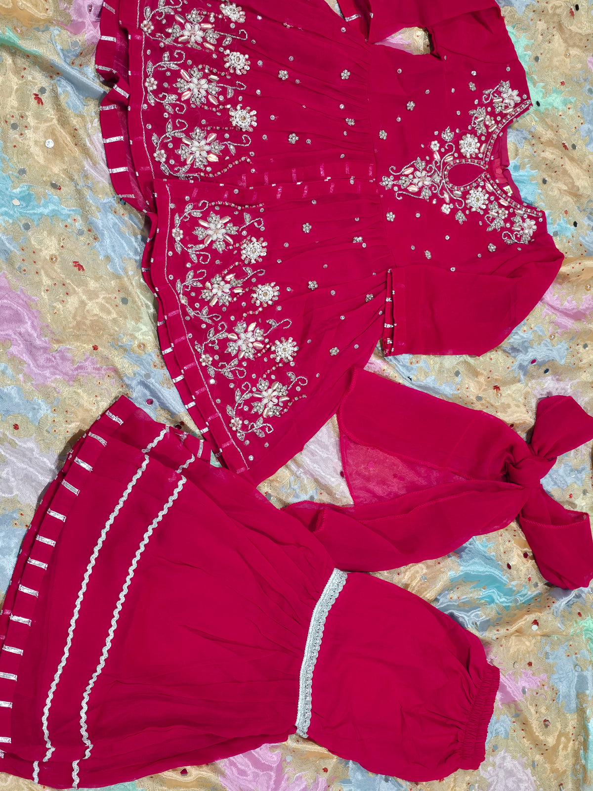 Girls magenta front-open chiffon frock featuring intricate hand embroidery, paired with a matching gharara accented by gotta lace trim and a coordinating chiffon dupatta.
