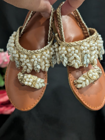 Girls wear mirrors, beaded work, and golden traditional footwear.