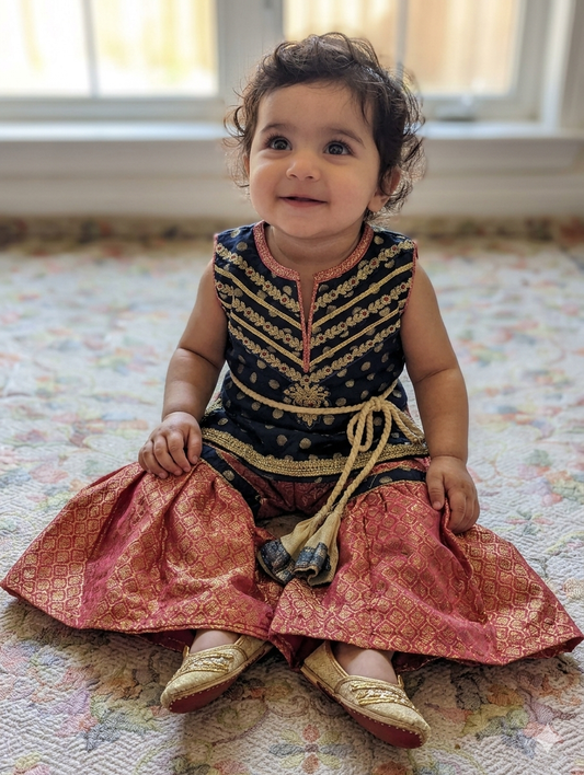 Infant sharara set featuring a navy blue polka-dot kurta paired with a pink and gold jacquard flared bottom and net duapatta
