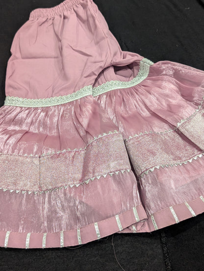 Girls' mauve kurta crafted from soft silk with an inner lining, featuring intricate hand-embellishments. It is paired with a matching gharara made from smooth, premium malai fabric and an ethereal moonlight dupatta.