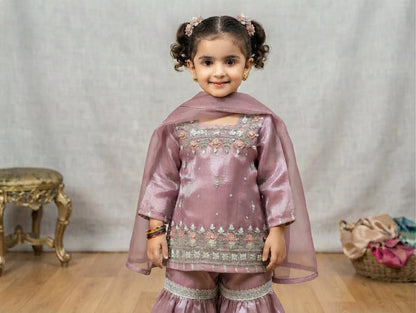 Girls' mauve kurta crafted from soft silk with an inner lining, featuring intricate hand-embellishments. It is paired with a matching gharara made from smooth, premium malai fabric and an ethereal moonlight dupatta.