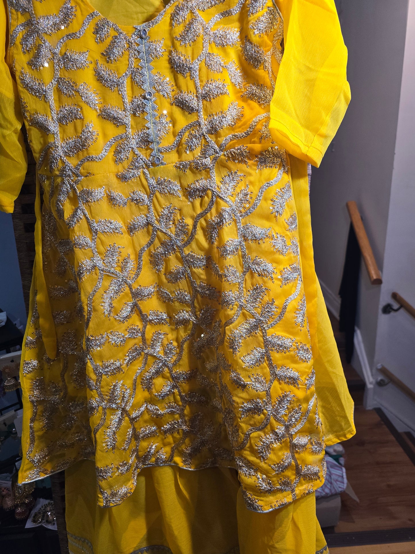Girl's vibrant yellow traditional ethnic outfit featuring frock intricate gold embroidery across the tunic and matching bottoms gharara.