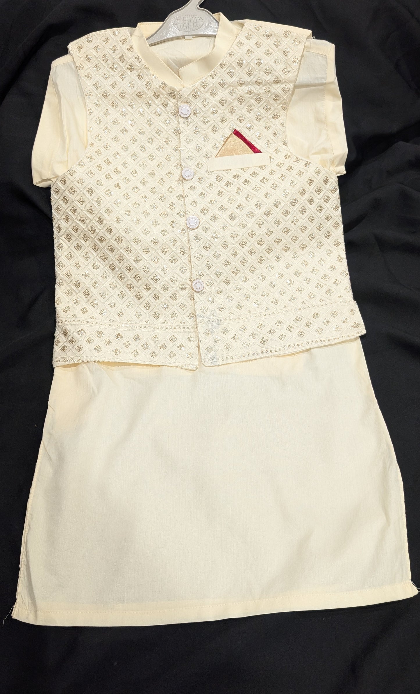 An off-white kurta, matching pants, and a gold embroidered waistcoat.