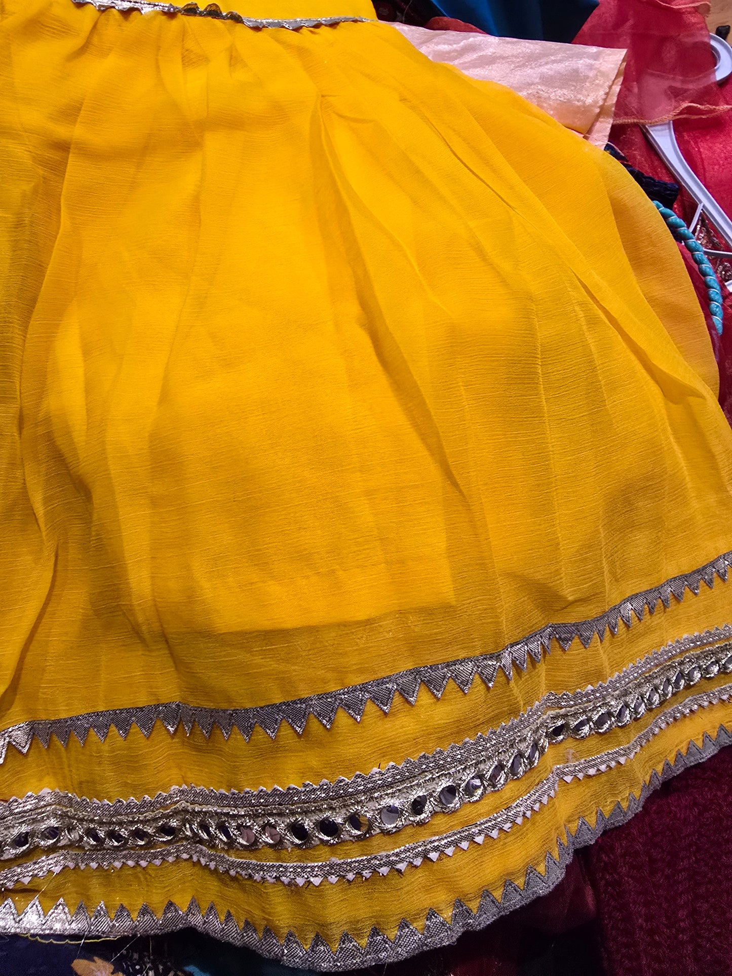 Girl's vibrant yellow traditional ethnic outfit featuring frock intricate gold embroidery across the tunic and matching bottoms gharara.