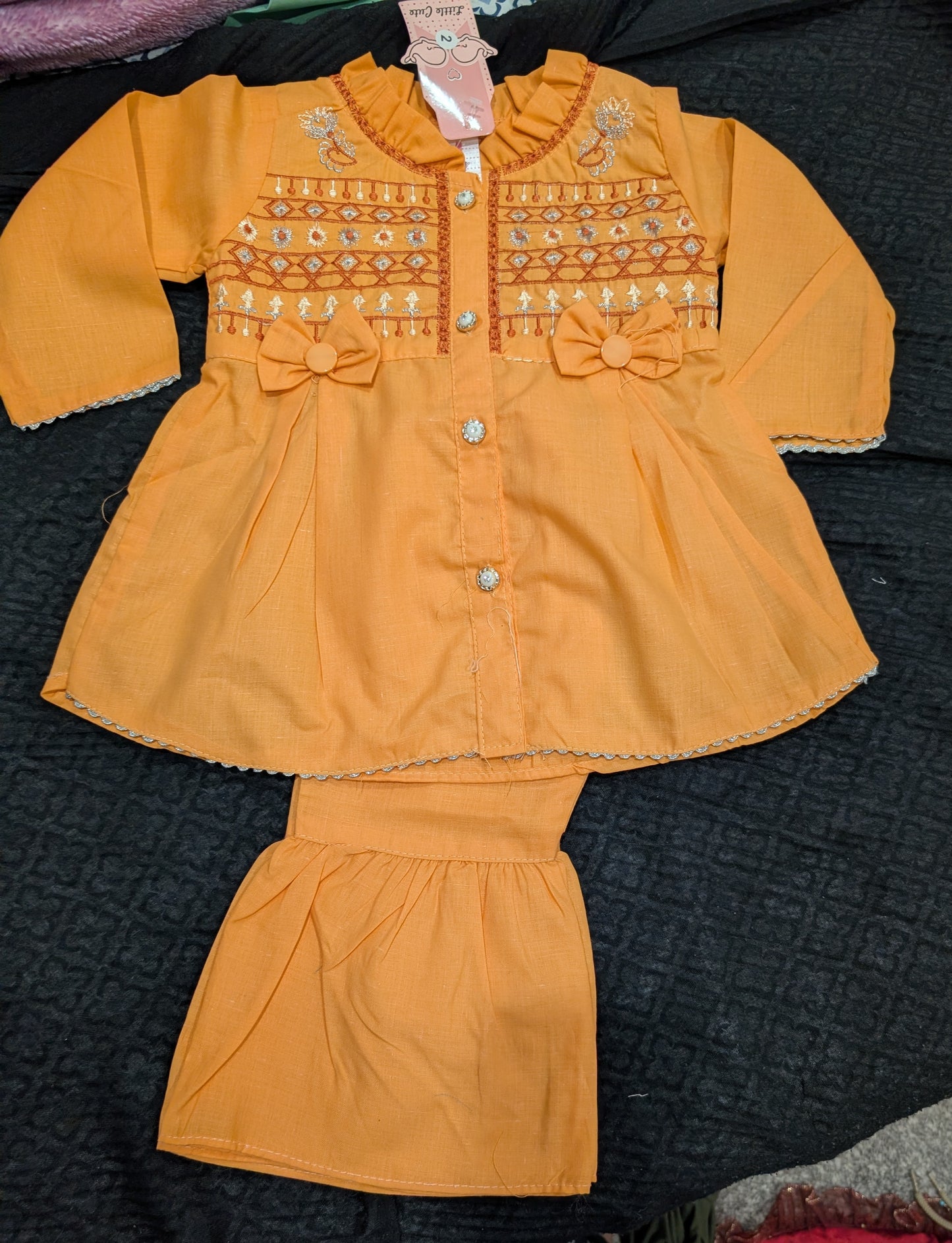 Infant  peach-orange peplum outfit  a high neckline, crystal buttons,  geometric embroidery, and matching flounced garara pants.
