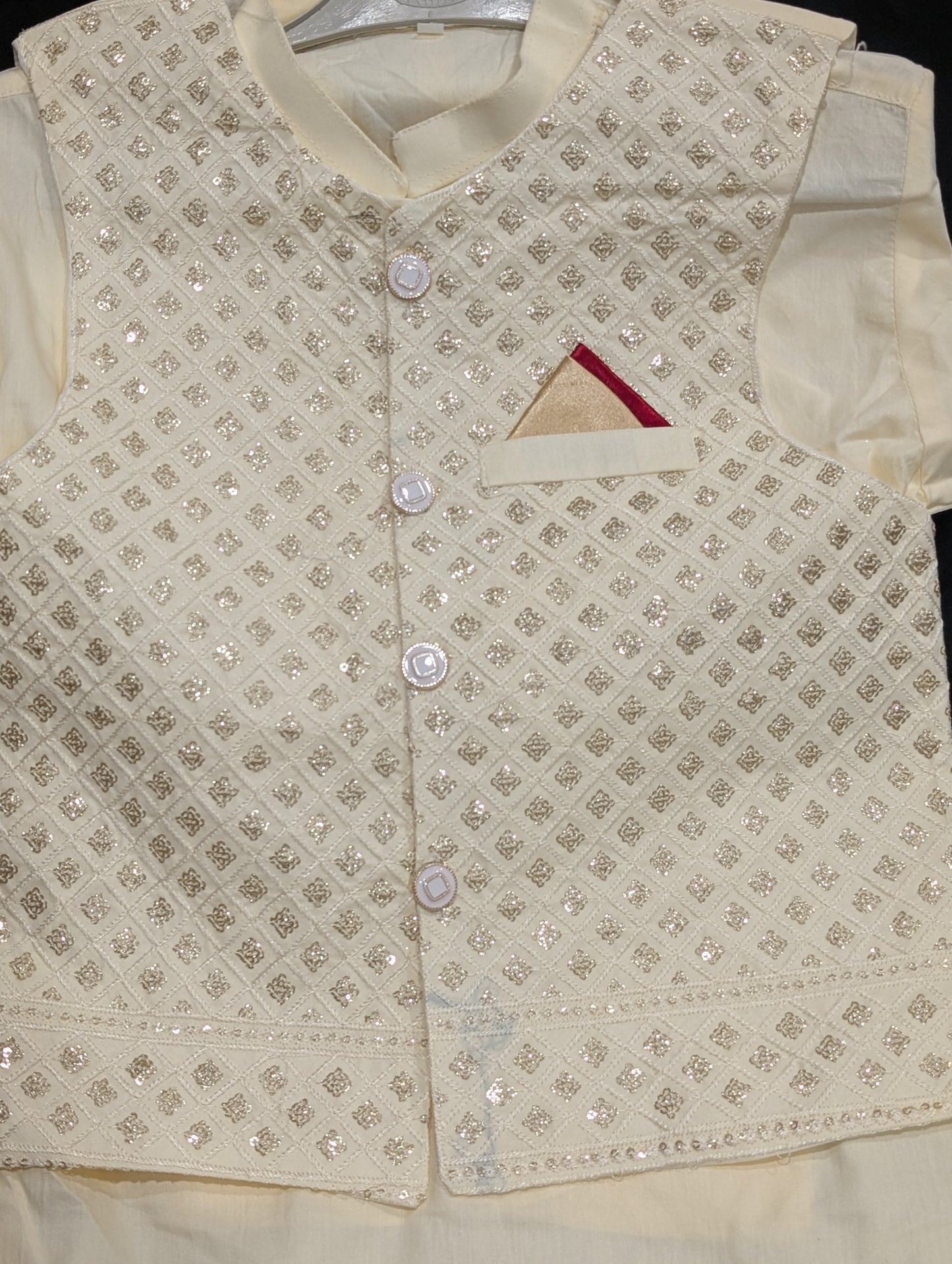 An off-white kurta, matching pants, and a gold embroidered waistcoat.